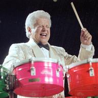 Percussionist Tito Puente plays a set of drums.