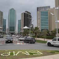 Traffic is seen in front of a series of high-rise buildings.
