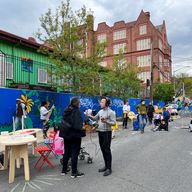 Reporter interviewing a person on a street that was closed to give kids a safe place to play.