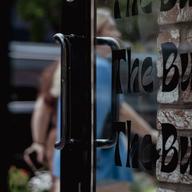A glass door that reads 'The Bush'