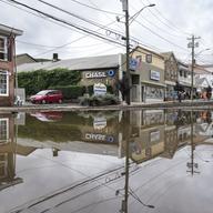 Residents, journalists, and emergency service workers walk around a flooded Main Street, Monday, July 10, 2023, in Highland Falls, N.Y. Heavy rain has washed out roads and forced evacuations in the No