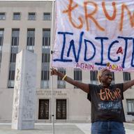 Nadine Seiler protest as she holds a banner outside federal court Tuesday, Aug. 1, 2023 in Washington. Former President Donald Trump has been charged by the Justice Department for his efforts to overt