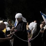 Israelis dressed as judges are tied together during a march in support of the judicial system during a protest against the plans by Prime Minister Benjamin Netanyahu's government to overhaul it, in Te