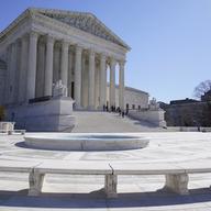 People stand on the steps of the U.S. Supreme Court, Feb.11, 2022, in Washington. 