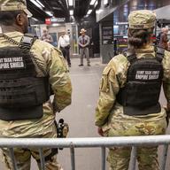 Members of the Armed Forces, including the National Guard, patrol the subway system in Penn Station as police officers check commuters' bags in New York on Thursday, March 7, 2024.
