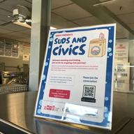 A sign promoting WNYC's Suds & Civics community engagement project -- featuring a cartoon graphic of a washing machine