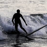 A person surfs, Saturday, Oct. 22, 2022, in the Far Rockaway neighborhood of the Queens borough of New York. 