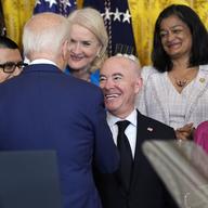 President Joe Biden shakes hands with Homeland Security Secretary Alejandro Mayorkas as other members of Congress watch an event marking the 12th anniversary of the Deferred Action of Childhood Arriva