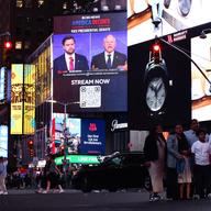 A screen displays the CBS vice presidential debate between US Senator and Republican vice presidential candidate J.D. Vance and Minnesota Governor and Democratic vice presidential candidate Tim Walz i