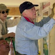 Former US President Jimmy Carter and former First Lady Rosalyn Carter attach siding to the front of a Habitat for Humanity home being built June 10, 2003 in LaGrange, Georgi