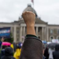 A protest holds up a fist during a No Kings Day rally and march on June 14, 2025 in Mineola, New York.