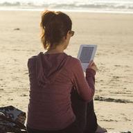 reading a Kindle on the beach