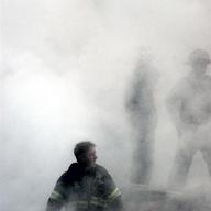 This US Navy photo released 17 September, 2001, shows a firefighter emerging from the smoke and debris of the World Trade Center September 14, 2001. 