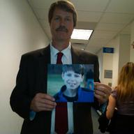 Michael Carey holds picture of his son Jonathan after testifying at state hearing on abuse at facilities for the disabled