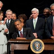 US President Barack Obama signs the Dodd-Frank Wall Street Reform and Consumer Protection Act alongside members of Congress, the administration and US Vice President Joe Biden