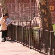 A woman reads the paper near the Grant housing project