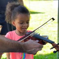 A girl playing the violin outdoors