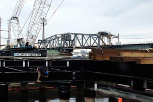 Workers have begun building a pier that will help with the construction of the Portal North Bridge. The projects is in limbo until the federal government commits to funding half of the $30 billion.
