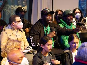 Audience speaker engages attendees and panelists during performance