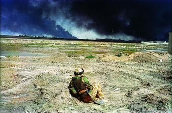 Basra April 7, 2003 - A British soldier watches black smoke rising from the southern port city of Basra. 