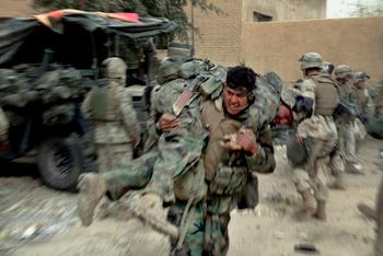Diwaniya April 7, 2003 - US Marines remove their dead and wounded after an artillery shell scored a direct hit on a US armored vehicle during an attack on Diwaniya Bridge. 