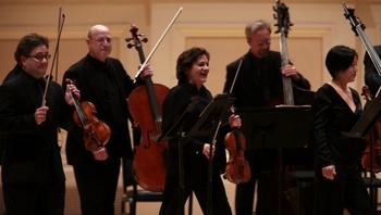 The violinists and violist of the St. Paul Chamber Orchestra stood to play Stravinsky's Concerto in D for strings