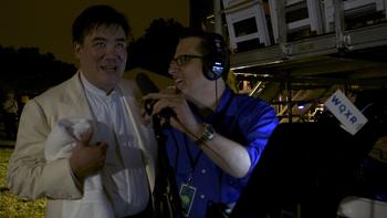 Alan Gilbert looks up at the fireworks following concert while talking with Elliott Forrest.