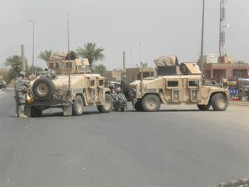 In this shot, Wilkens' squad fixes a broken down humvee in Baghdad.