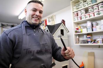 Carlos, a dollhouse builder, displays his favorite tool.