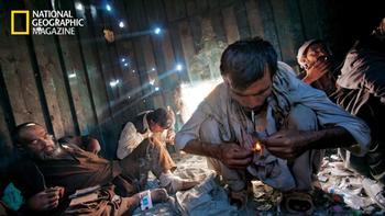 Sunlight pours through shrapnel holes in a shipping container in Kabul's Old City, where users gather for a hit of opium.