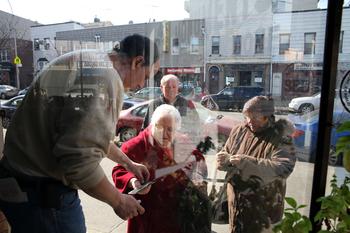 Jerry sells bread to neighbors outside of Grande Monuments.