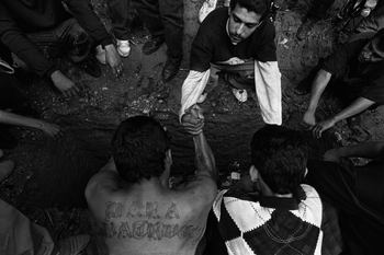 Donna De Cesare. San Salvador, El Salvador 1996. Gang members make a pact of revenge over the grave of a slain  leader.