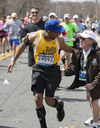 A member of the Tufts marathon team greets coach Megerle.