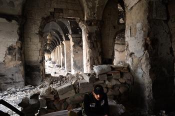 A Syrian rebel fighter takes a rest at a destroyed section of the Umayyad Mosque complex in the old city of Aleppo on April 16, 2013. 