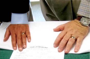David Michener and Bill Ives place their hands on their marriage certificate.