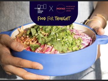 A person holds a dutch oven filled with Filipino food