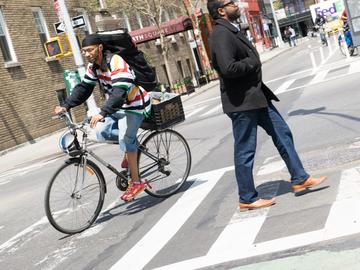 A man rides his bike through an intersection near Washington Square Park on a sunny April day. 