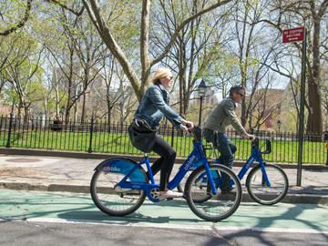 Cyclists ride Citi Bikes past Washington Square Park in late April.