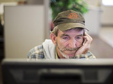 In this Oct. 20, 2014 photo, unemployed coal miner Eddie Jones looks for jobs on a computer at the Kentucky Career Center in Harlan, Ky. 