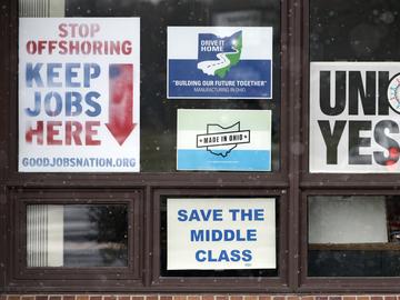In this Nov. 27, 2018 photo, signs hang from windows at the UAW Local 1112 union hall, in Lordstown, Ohio. 