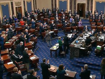 In this image from video, senators stand and applaud support staff, before the final vote on the Senate version of the COVID-19 relief bill in the Senate at the U.S. Capitol in Washington, Saturday.
