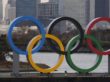 A worker is dwarfed by the Olympics Rings on a barge Friday, Jan. 17, 2020, in the Odaiba district of Tokyo.