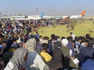 In this Monday, Aug. 16, 2021 file photo U.S. soldiers stand guard along the perimeter at the international airport in Kabul, Afghanistan. Hundreds of Western nationals and Afghan workers have been fl