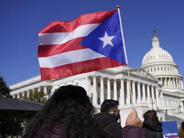 A woman waves the flag of Puerto Rico during a news conference on Puerto Rican statehood on Capitol Hill in Washington, Tuesday, March 2, 2021. 