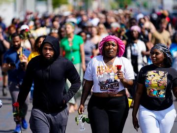 People march to the scene of a shooting at a supermarket in Buffalo, N.Y., Sunday, May 15, 2022.