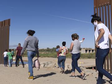 A group of Brazilian migrants make their way around a gap in the U.S.-Mexico border in Yuma, Ariz., seeking asylum in the U.S. after crossing over from Mexico, June 8, 2021. 