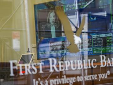 A television screen displaying financial news including the stock price of First Republic Bank is seen inside one of the bank's branches in the Financial District of Manhattan, March 16, 2023.