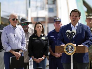 President Joe Biden listens as Florida Gov. Ron DeSantis speaks after they toured an area impacted by Hurricane Ian on Wednesday, Oct. 5, 2022, in Fort Myers Beach, Fla.
