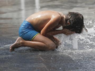 A kid cools off in a public fountain in Milan, Italy, Wednesday, July 15, 2015. Europe's heat wave has pushed the mercury to levels as high as 40 degrees Celsius (104 degrees Fahrenheit).