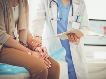 A doctor holding a patient's hand in a show of emotional support